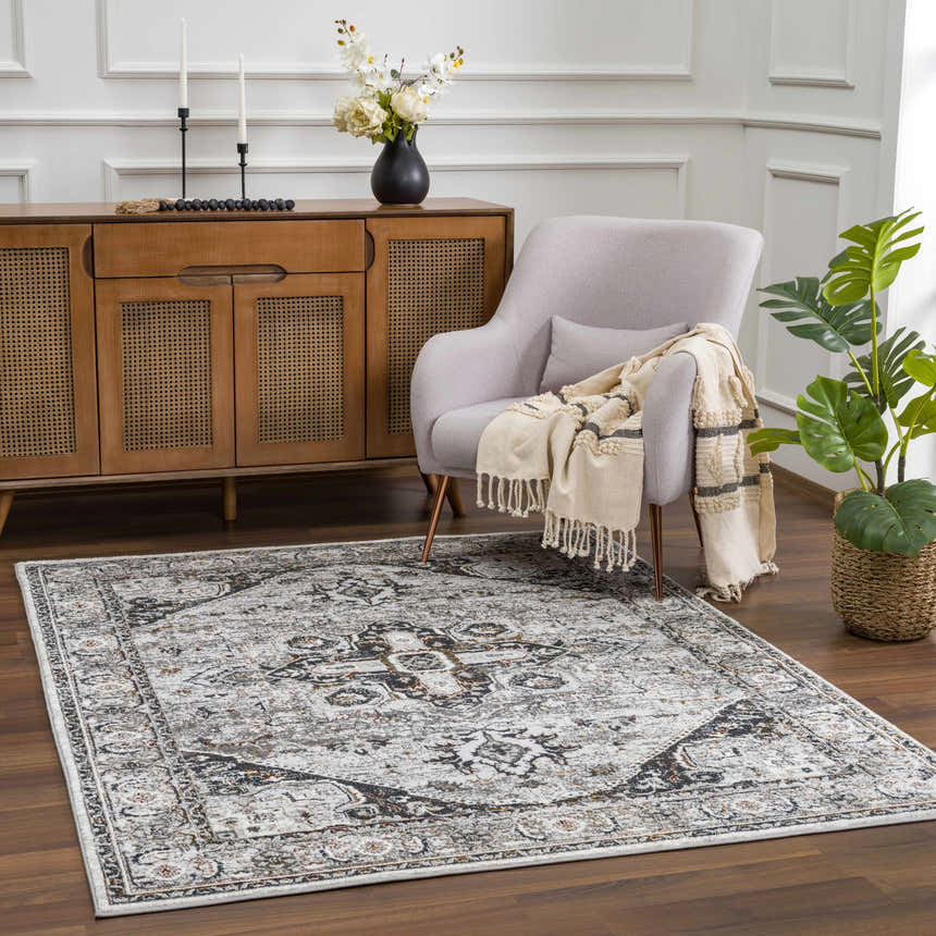 Living room scene with Liverpool Dark Gray Area Rug, light gray chair, and wood cabinet. Roomscene-Rectangle