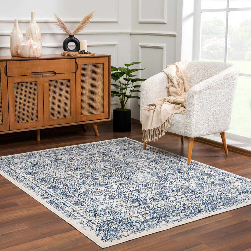 Living room scene with a Michie Blue Area Rug, white chair, and wood cabinet. Roomscene-Rectangle