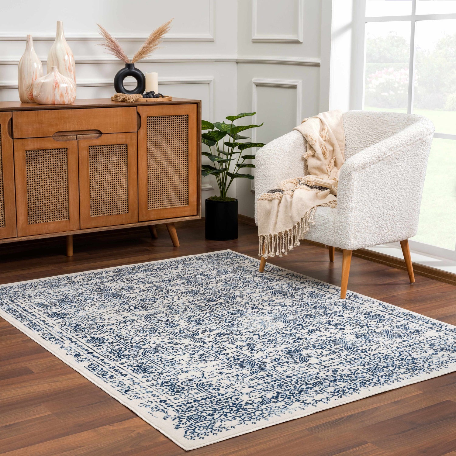Living room scene with a Michie Blue Area Rug, white chair, and wood cabinet. Roomscene-Rectangle