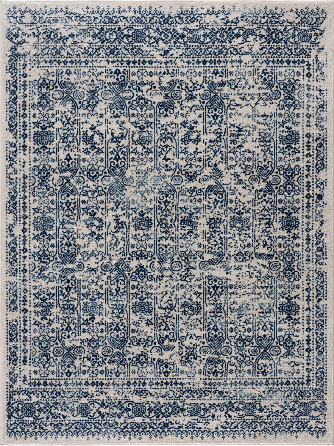 Close-up of the Michie Blue Area Rug featuring a traditional, distressed dark blue and white pattern. Design-Rectangle