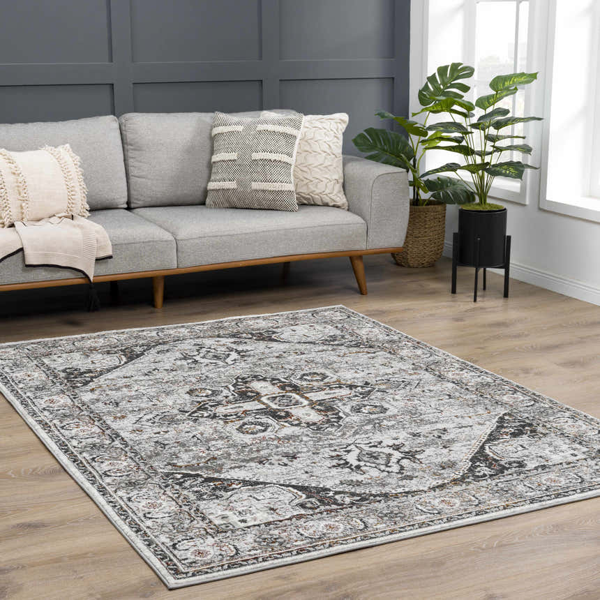 Living room scene with gray sofa and Liverpool Dark Gray Area Rug featuring charcoal, rust, and off-white tones. Roomscene-Rectangle