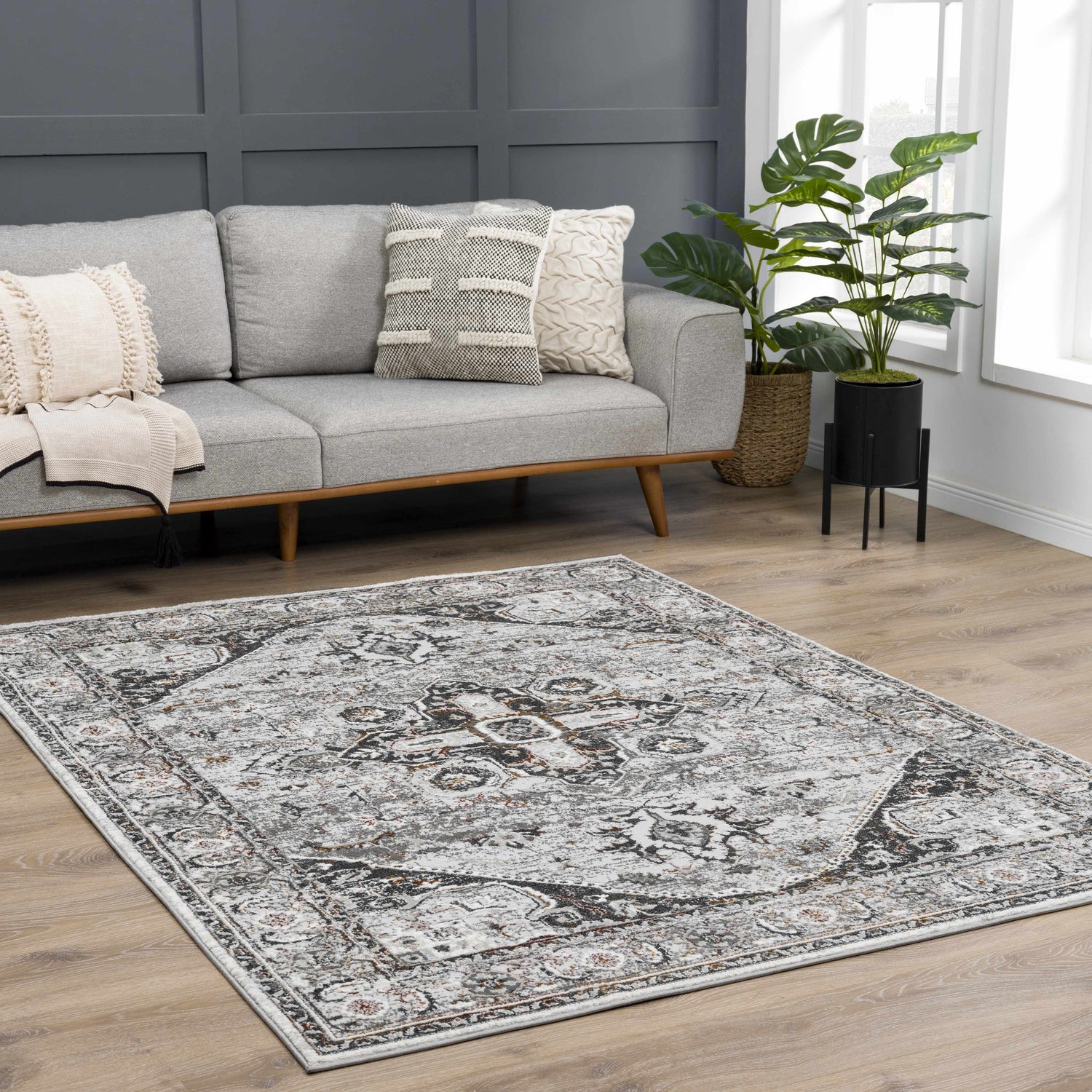 Living room scene with gray sofa and Liverpool Dark Gray Area Rug featuring charcoal, rust, and off-white tones. Roomscene-Rectangle