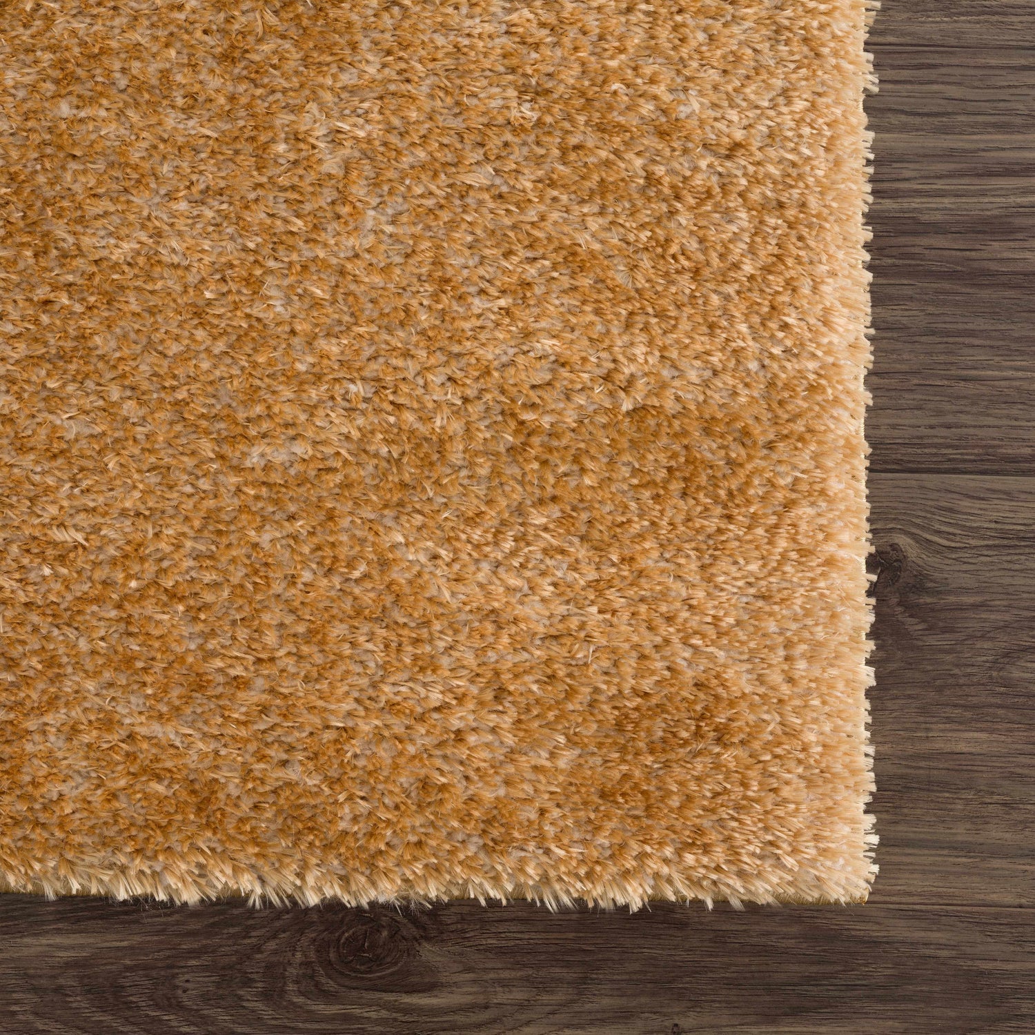 Close-up of the Heavenly Solid Mustard Plush Rug showing its soft texture and color on dark wood flooring. Swatch