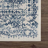 Close-up of the Michie Blue Area Rug showing its dark blue, light blue, and white bohemian pattern and machine woven texture. Swatch
