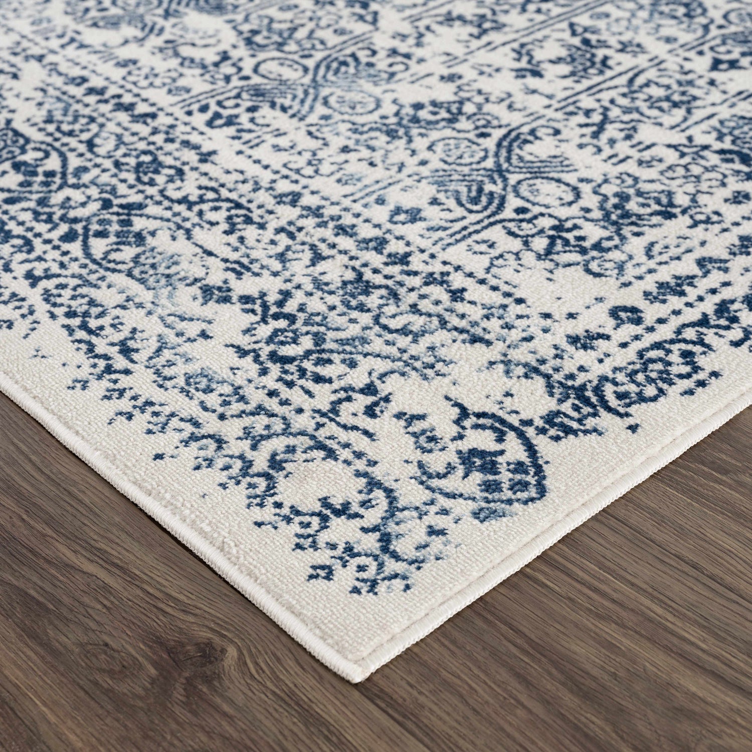 Close up of the Michie Blue Area Rug showing its traditional blue and white pattern. Corner