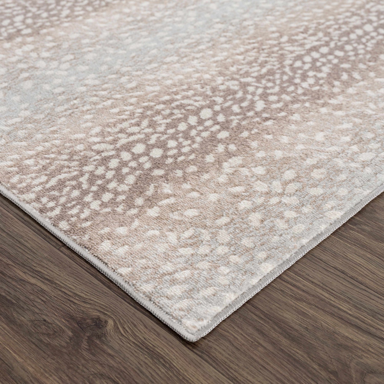 Close-up of the Pointblank Tan Leopard Print Rug showing its ivory and tan animal print design and soft texture. Corner