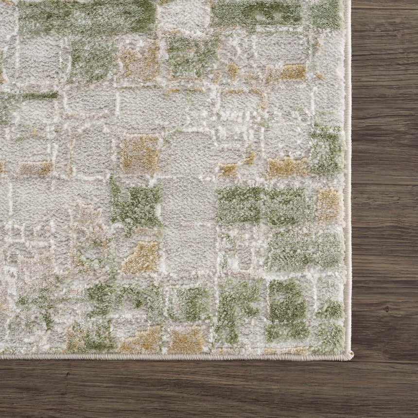Close-up of the Liveri Green Mosaic Rug. Abstract design with green and gold tones on a textured, machine-woven pile. Swatch