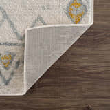 Close-up of the Istanbul Aztec Area Rug showing off-white, gray, and mustard geometric design and rug backing. Fold