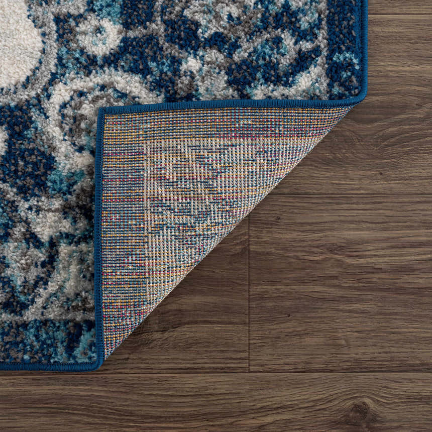 Close-up of the Istanbul Blue Area Rug showing its ivory, navy, and gray Bohemian pattern and machine-woven construction. Fold