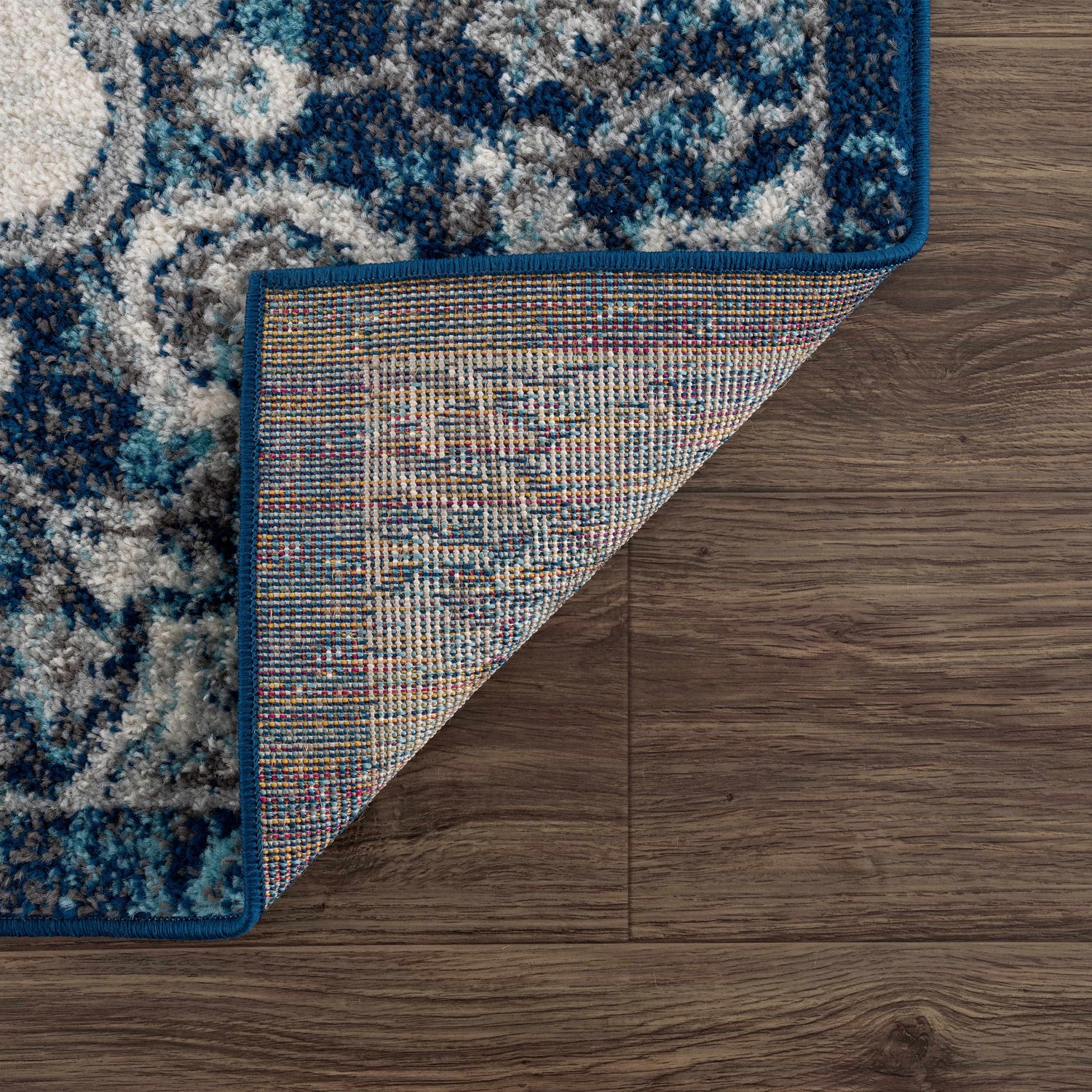 Close-up of the Istanbul Blue Area Rug showing its ivory, navy, and gray Bohemian pattern and machine-woven construction. Fold