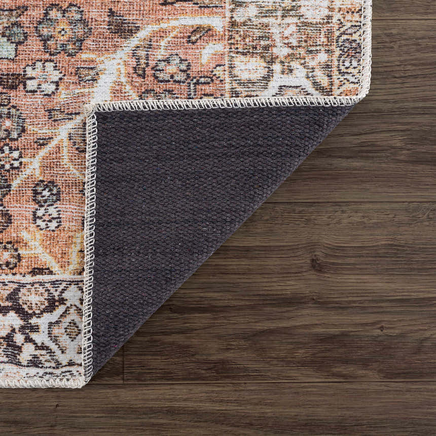 Close-up of Bian Washable Area Rug showing traditional Persian design, peach, beige, and brown colors, and non-slip backing. Fold