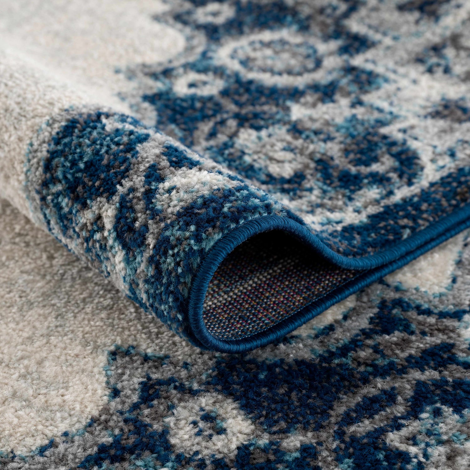 Close-up of the Istanbul Blue Area Rug showing its ivory and navy Persian-style pattern and soft texture. Fold