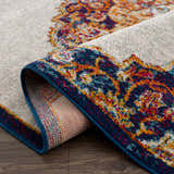 Close-up of the Istanbul Orange Area Rug showing the colorful Persian-inspired design and navy blue trim. Fold