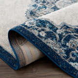Close-up of the Istanbul Blue Area Rug showing the ivory and navy Persian-style pattern and the rug's construction. Fold