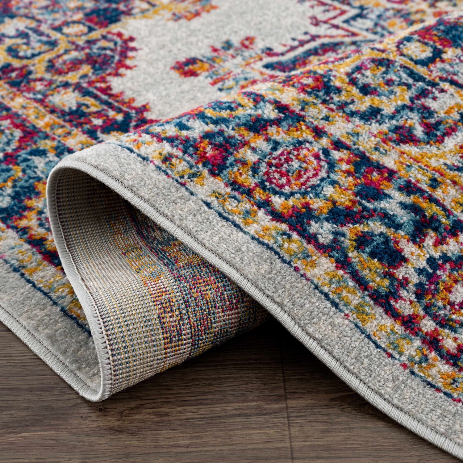 Close-up of the Istanbul Medallion Orange Area Rug, showcasing the ivory, navy, and orange bohemian design and woven texture. Fold