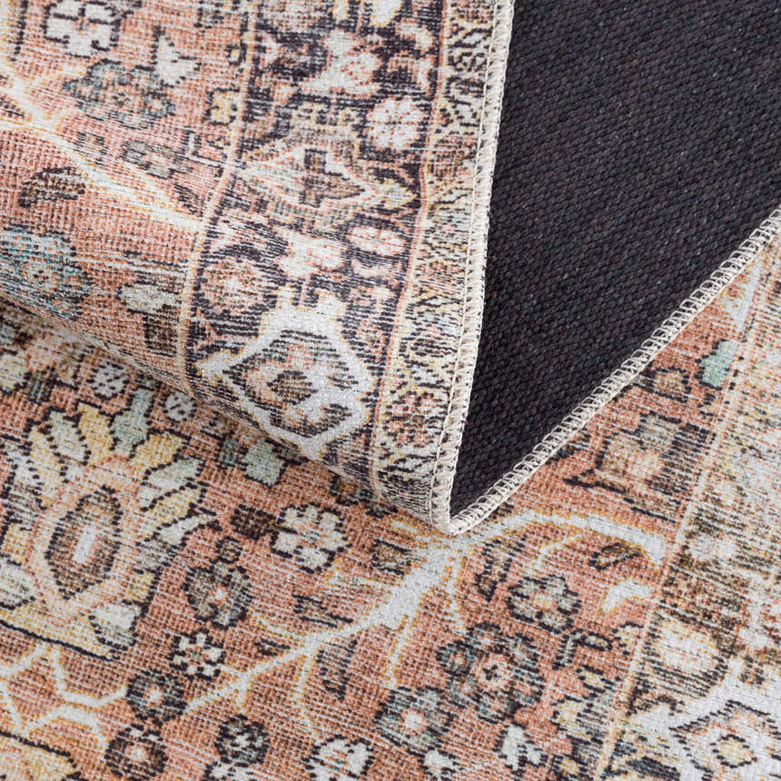 Close-up of the Bian Washable Area Rug showing its Persian-style pattern in peach, beige, and blue tones and its gray backing. Fold