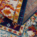 Close-up of the Istanbul Vintage Navy Area Rug showing its ivory, navy, orange, and pink floral pattern and texture. Fold