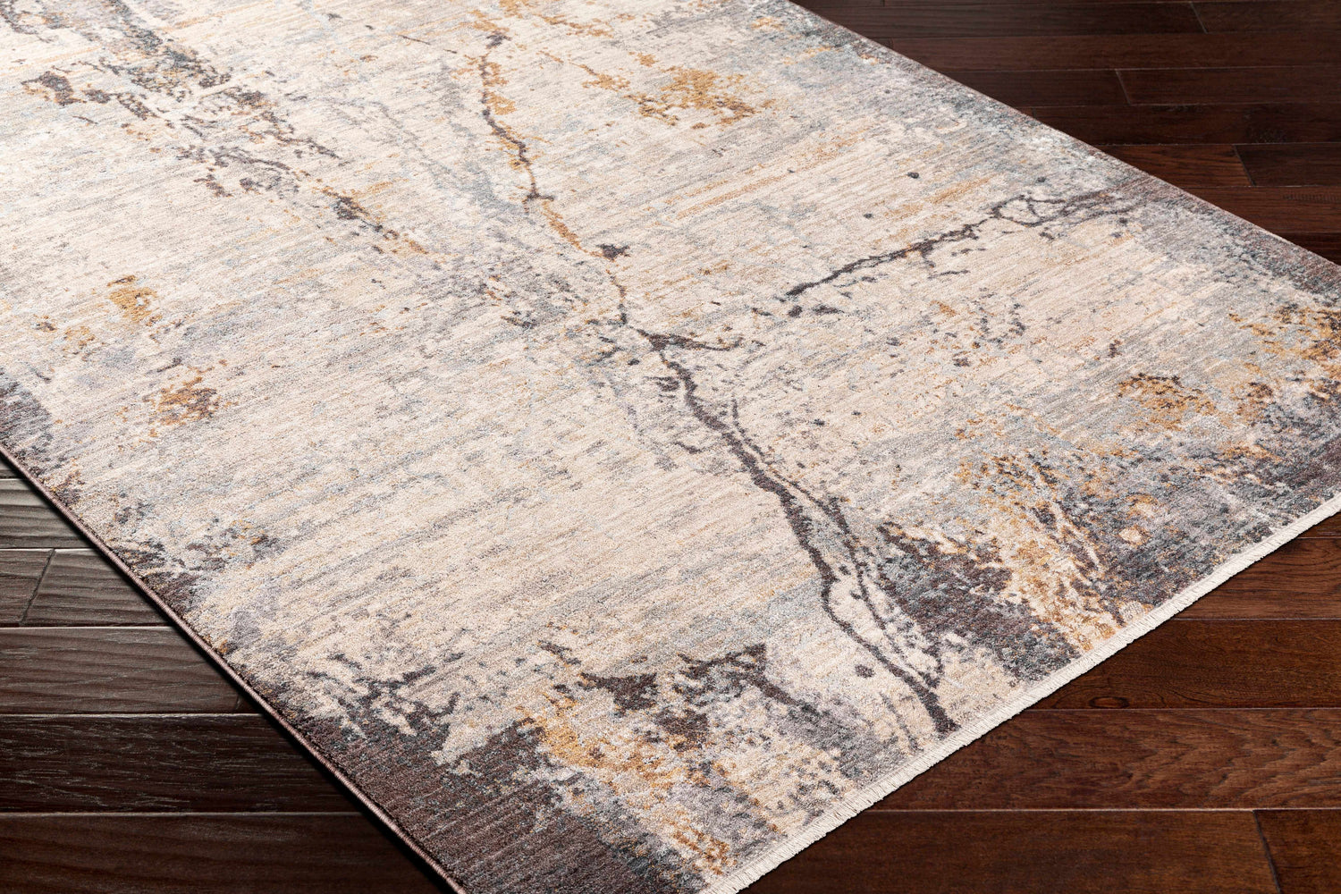 Close-up of the Alexi Luxe Rug with Fringes. Beige, gray, and mocha tones create a contemporary abstract pattern. Corner