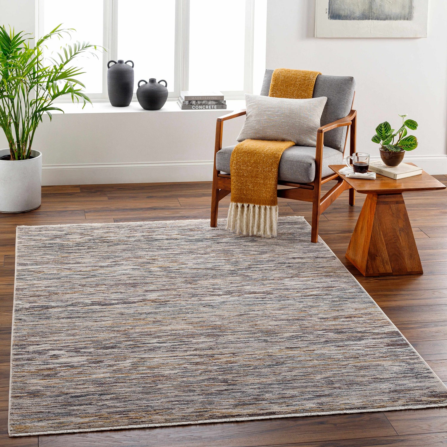Living room scene with Apria Area Rug in beige, brown, and gray. Contemporary style with chair, side table, and plants. Roomscene-Rectangle