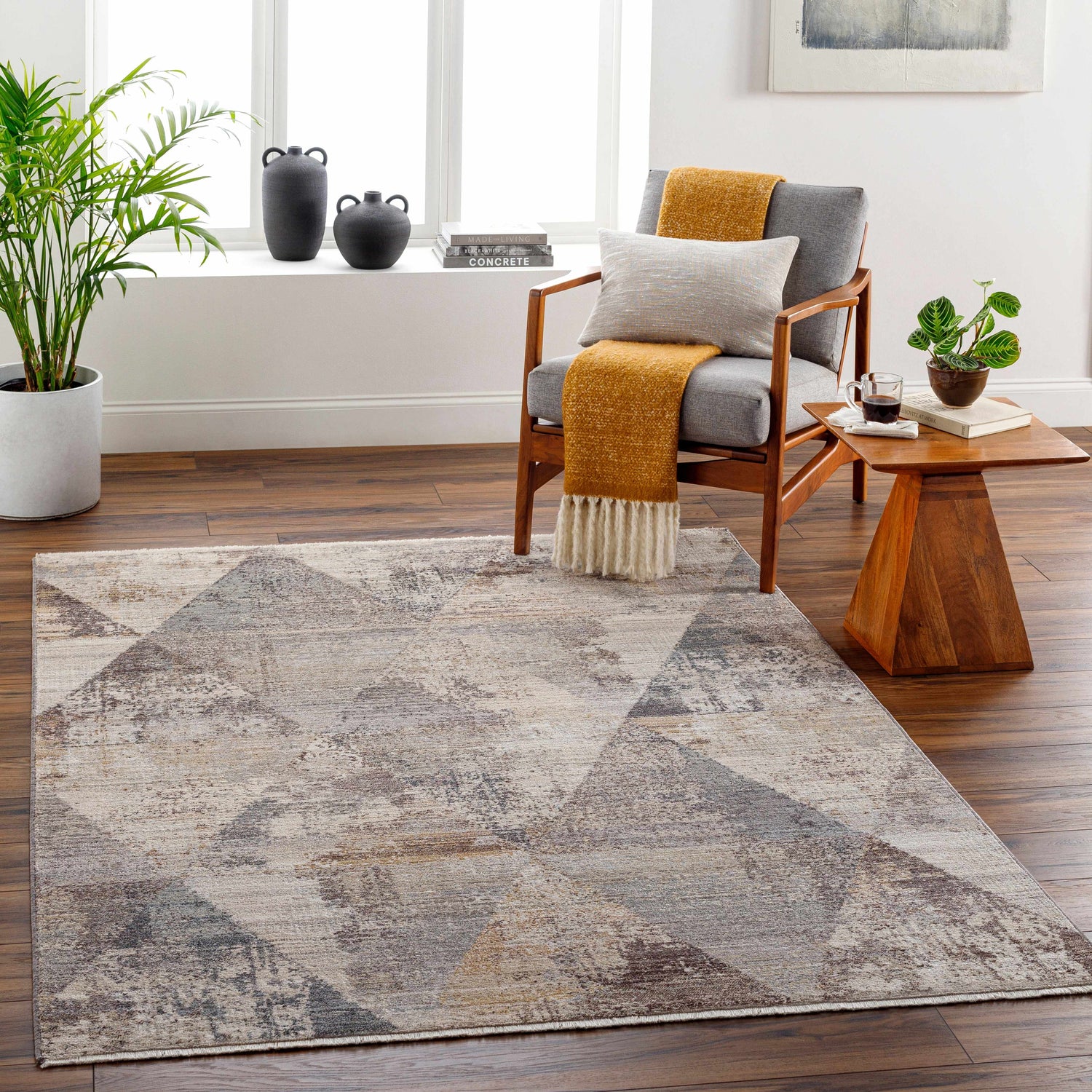 Living room scene with a Birdy Area Rug in beige, brown, and gray geometric pattern under a mid-century modern chair. Roomscene-Rectangle