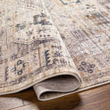 Close-up of the Iiona Area Rug showing the traditional pattern, brown, gray, and lambswool colors, and soft texture. Fold
