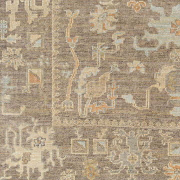 Close-up of the hand-knotted Berke Area Rug. Features a traditional pattern in brown, gray, dusty sage, and off-white wool. Swatch