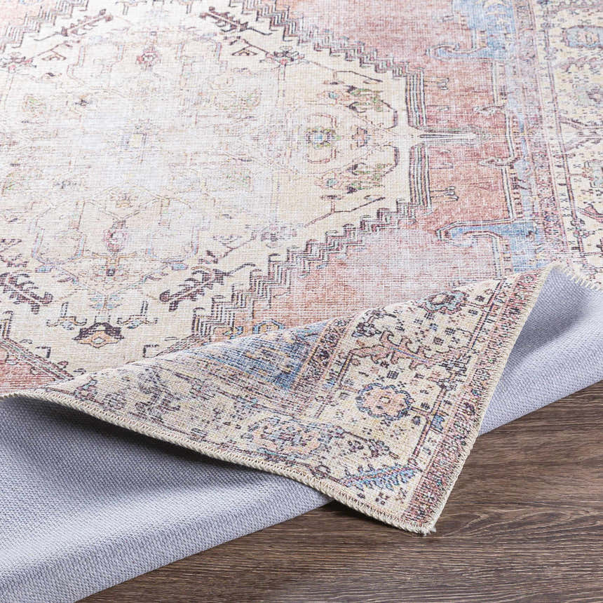 Close-up of the Sacriston Washable Area Rug showing its traditional, bohemian design and colors like aqua, rose, and brown. Fold