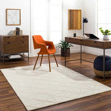 Home office with Jevau Beige Geometric Rug, wood desk, orange chair, and dark wood floors. Modern, bright, and inviting space. Roomscene-Rectangle