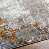 Close-up of the Ansel Area Rug featuring a contemporary abstract design in ivory, gray, blue, and rust tones. Texture