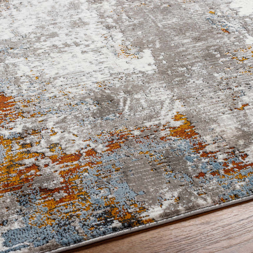 Close-up of the Ansel Area Rug featuring a contemporary abstract design in ivory, gray, blue, and rust tones. Texture
