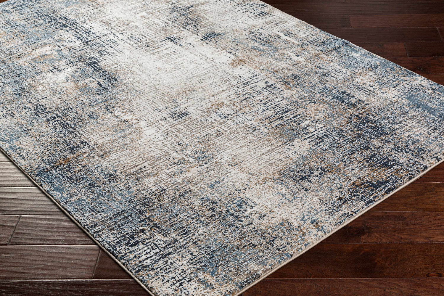 Close-up of the Ervin Blue Area Rug showcasing its abstract pattern and colors: ivory, gray, brown, and navy. Corner