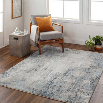 Living room scene with the Ervin Blue Area Rug, gray chair, wood floors, and natural light. Roomscene-Rectangle