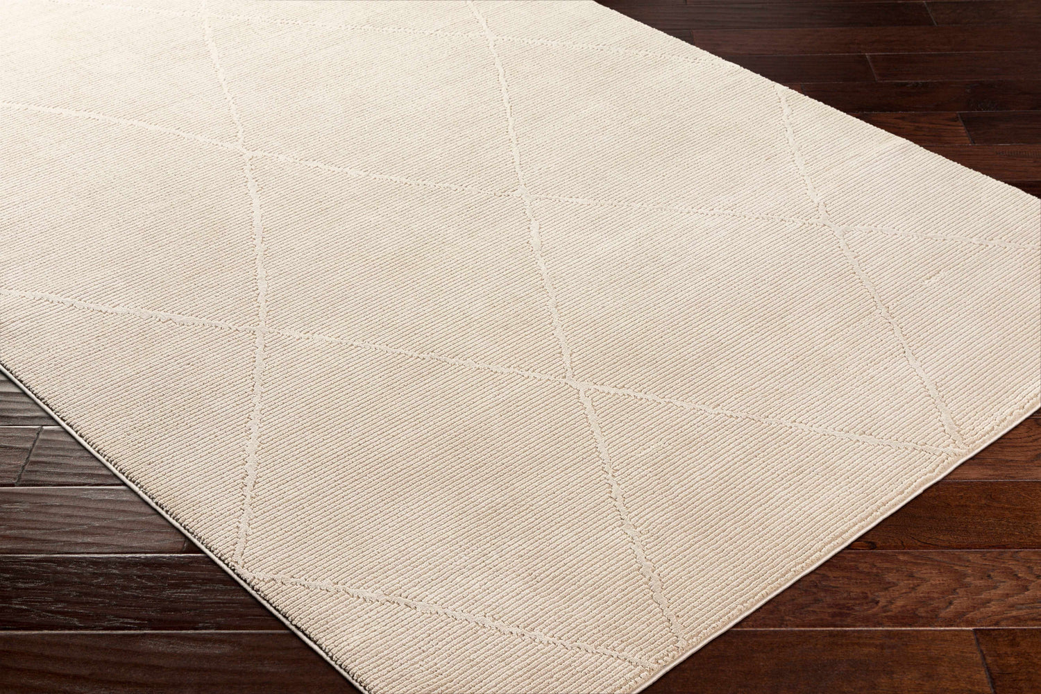 Close-up of the Aldis Tan Plush Textured Washable Rug showing its plush texture and geometric diamond pattern. Corner