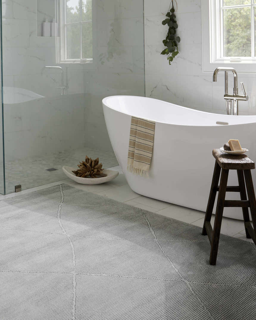 Serene bathroom scene with a white tub and the grey textured Aldis rug, adding warmth and style to the space. Roomscene-Rectangle