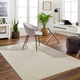 Bright home office with a Lambswool Kini Plush Textured Washable Rug, desk, gray chair, and plants. Roomscene-Rectangle