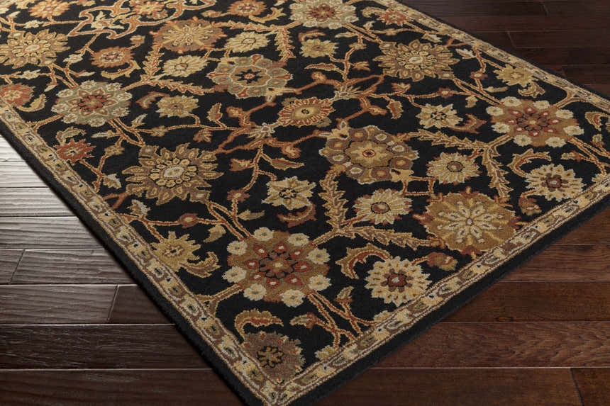 Close-up of the Salix Hand Tufted Black Wool Rug, featuring a floral pattern in brick red, camel, mustard, and olive tones. Corner