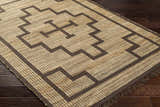 Close-up of the hand-woven Licha Jute Rug. Camel jute with eggplant geometric pattern and fringe detail. Farmhouse style. Corner