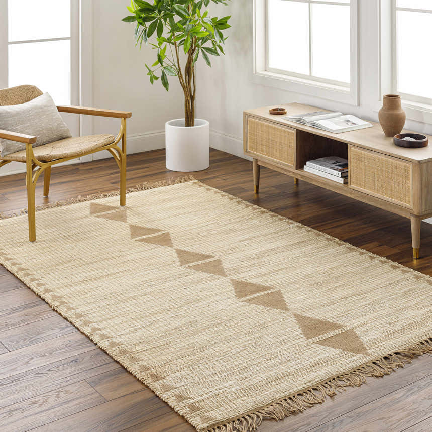 Living room scene with a Marie Jute Rug in ash and khaki, woven texture, geometric pattern, with chair and console table. Roomscene-Rectangle