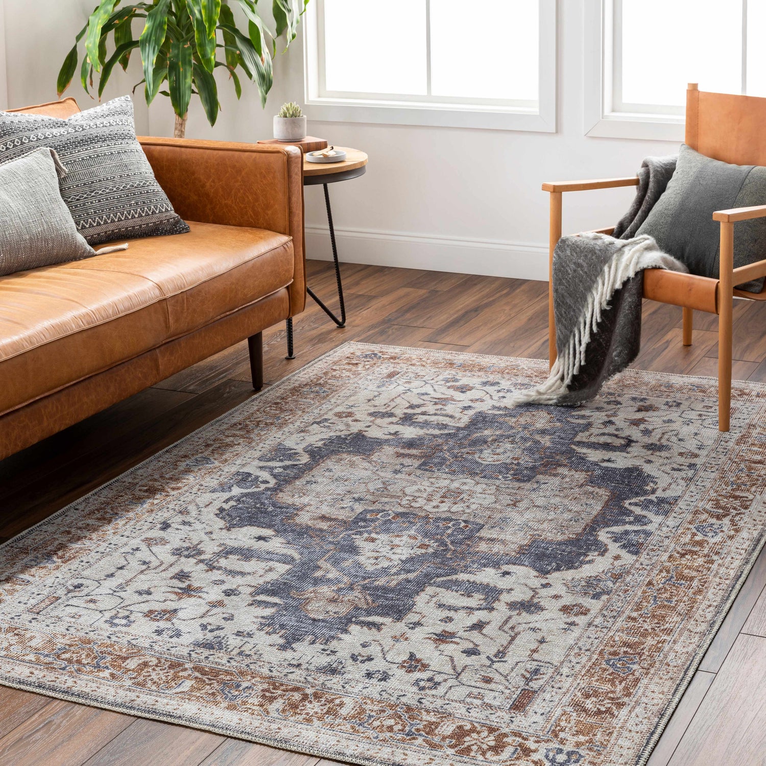 Living room scene with tan leather sofa and Egor Washable Area Rug in dark beige, dark red, and ink. Farmhouse style. Roomscene-Rectangle