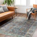 Living room scene with a traditional Kaif Washable Area Rug in multi brown and teal, leather sofa, and wood floors. Roomscene-Rectangle