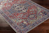 Close-up of Reza Red Washable Rug on dark wood floor. Features traditional, farmhouse style with garnet, bone, and cloud gray colors. Corner