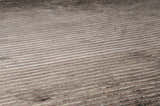 Close-up of the hand-knotted Sanatoga Area Rug. Features a textured, striped design in neutral beige and brown tones. Texture