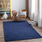 Living room scene with dark blue Sarona Area Rug, wood chair, and modern decor. Roomscene-Rectangle