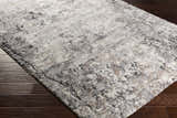 Close-up of the Satsop Rock Pattern Thick Rug showing its black, charcoal, gray, ivory, and tan colors and textured design. Corner