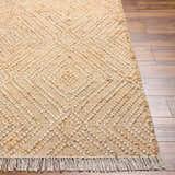 Close-up of beige Dunne Area Rug showing jute texture, diamond pattern, and fringe detail on a wood floor. Front