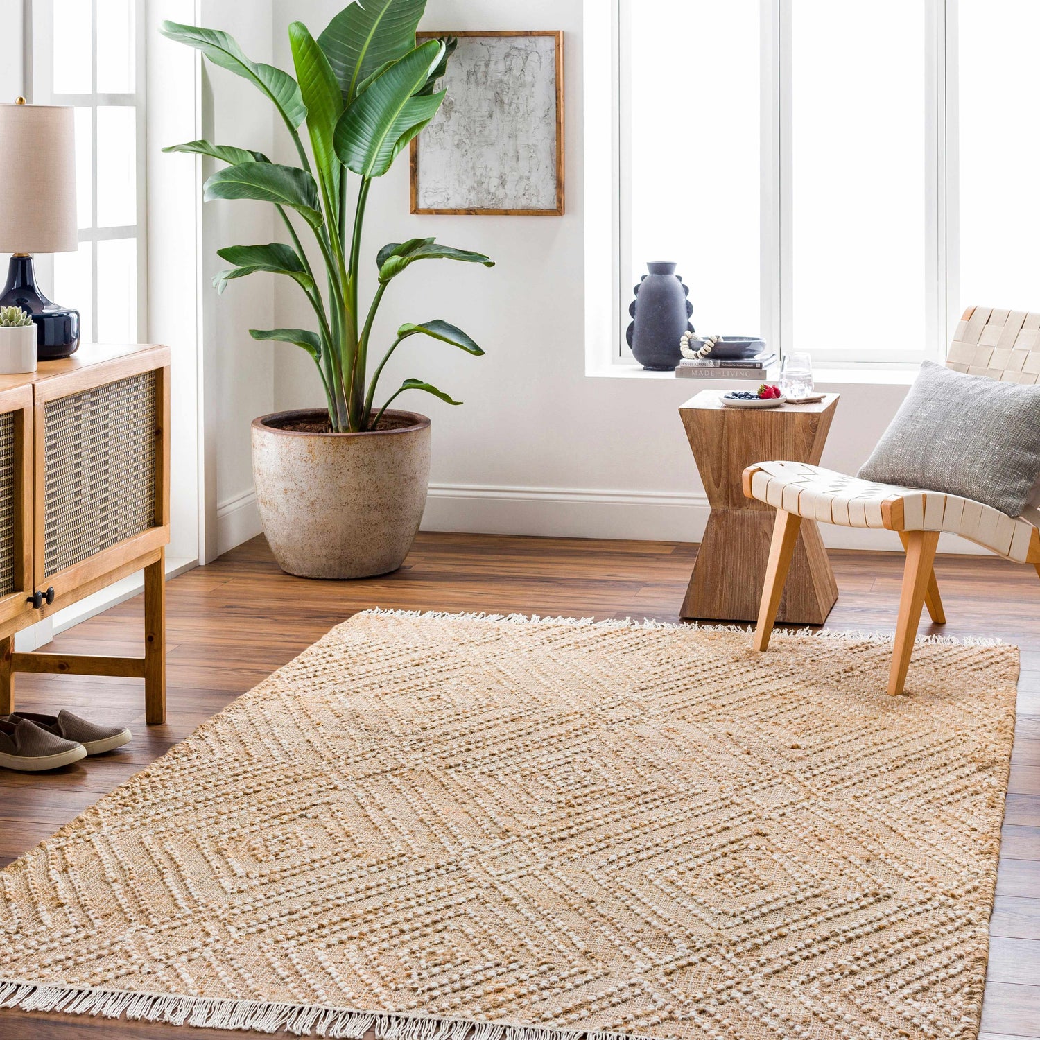 Living room scene with a jute Dunne Area Rug, wood furniture, and a large potted plant. Roomscene-Rectangle