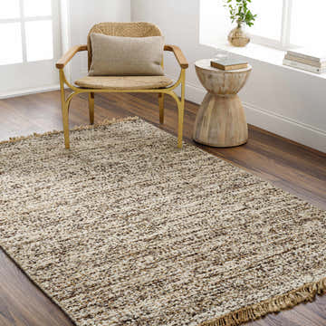 Living room scene with a Tan Gopi Area Rug, woven chair, and wood accent table creating a neutral, textured, and inviting space. Roomscene-Rectangle