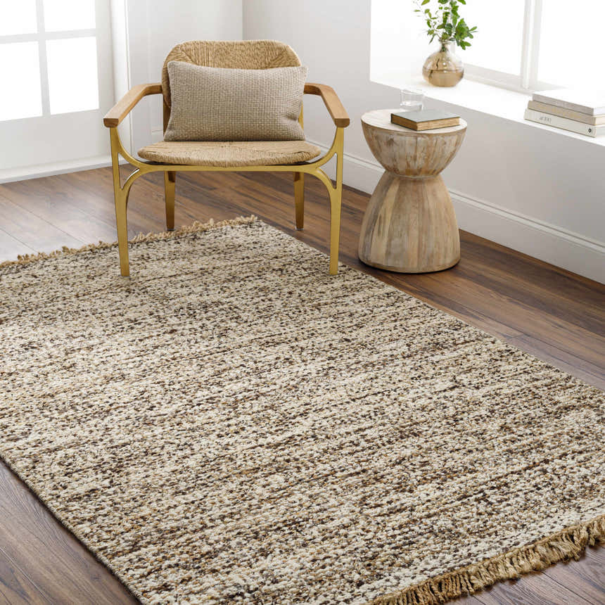 Living room scene with a Tan Gopi Area Rug, woven chair, and wood accent table creating a neutral, textured, and inviting space. Roomscene-Rectangle