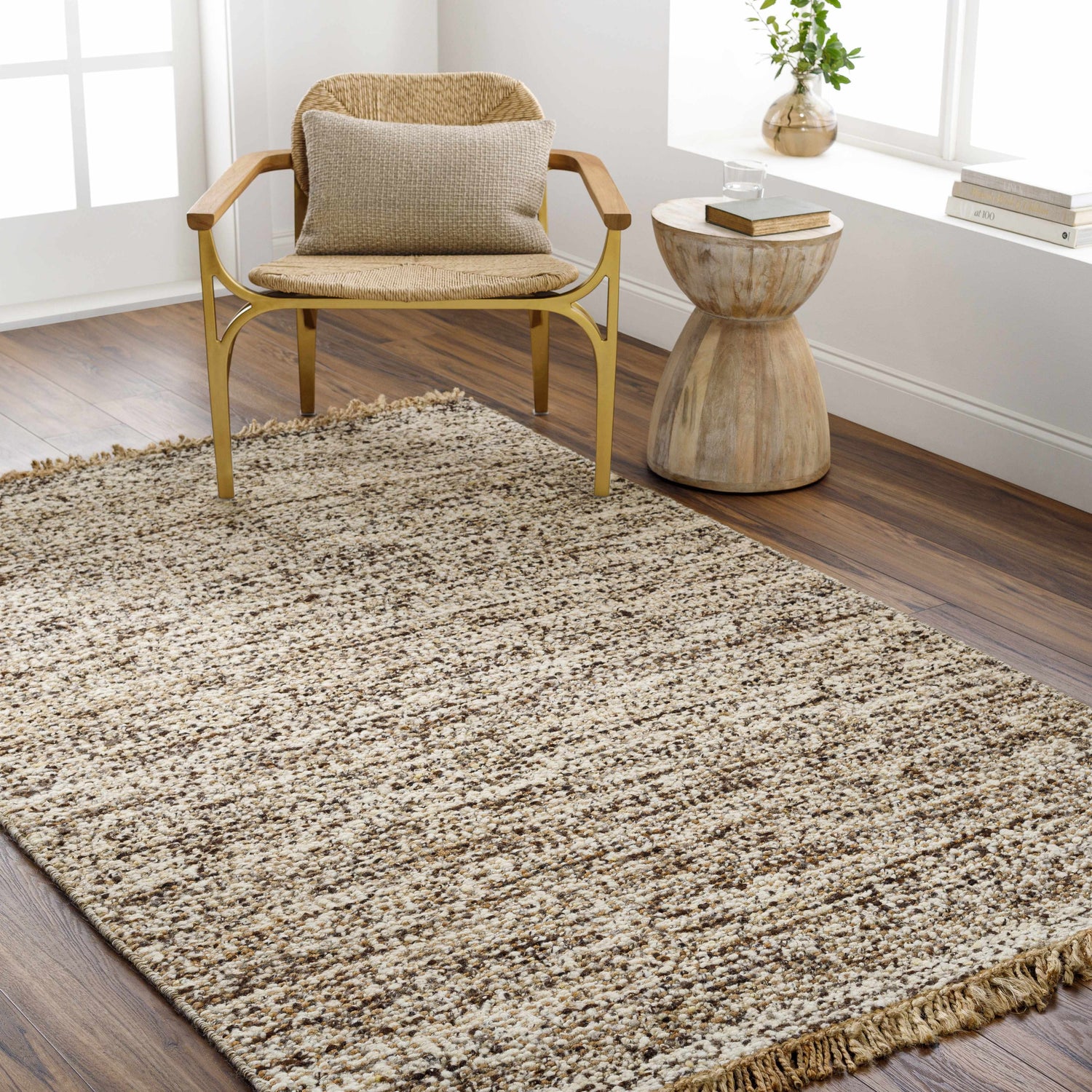 Living room scene with a Tan Gopi Area Rug, woven chair, and wood accent table creating a neutral, textured, and inviting space. Roomscene-Rectangle