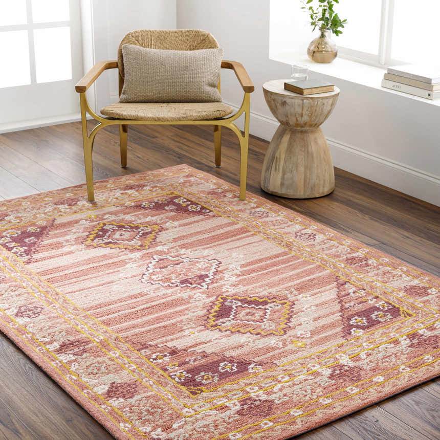 Sunlit room scene with Alena Peach Wool Blend Area Rug, woven chair, and wood side table. Roomscene-Rectangle